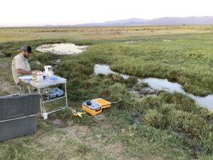 Photo showing water sampling equipment beside a cold spring in a valley