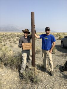 Photo of Paul Schwering and Nick Hinz standing beside one of the abandoned oil and gas exploration wells in central Steptoe Valley, eastern NV.